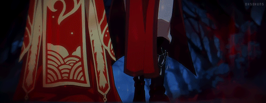 Xie Lian and Hua Cheng, both dressed in red, walk through a dark forest on a rainy night. 